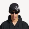 Boné masculino com inscrição em cursivo em preto desbotado