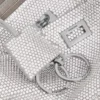 Pochette feminina Rodeo com alça tipo sling e strass em cinzento fumado